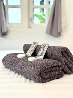 a brown towel with two remote controls on top of it at Vagary Pangkor in Pangkor