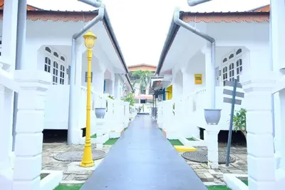 a corridor of a white building with a yellow pole at Vagary Pangkor in Pangkor