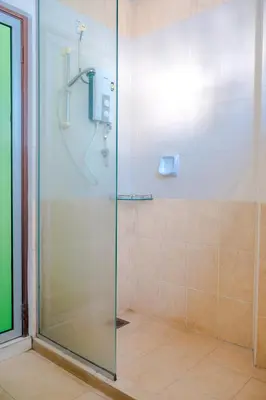 a shower with a glass door in a bathroom at K West Hotel in Sitiawan