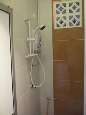 a shower with a shower head in a bathroom at Fastbook Bendera Home 8 & 10pax in Ayer Itam