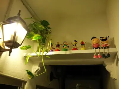 a shelf with figurines on top of a fireplace at Fastbook Bendera Home 8 & 10pax in Ayer Itam