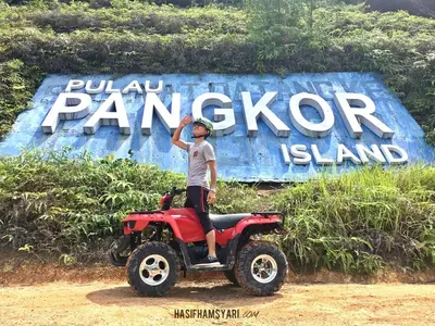 a man standing on a four wheeler in front of a sign at Syaqisya Homestay in Seri Manjung