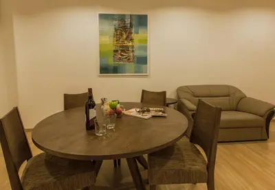 a dining room with a table and a couch at Luxfort 118 Service Suites in George Town