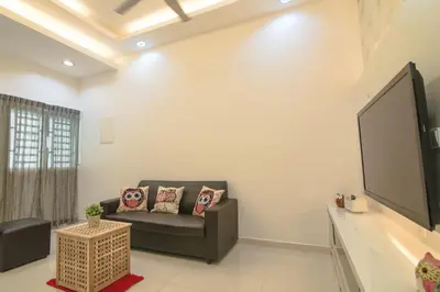 a living room with a couch and a flat screen tv at Landed Cozy House Near SPICE, Airport in Kampong Manggis