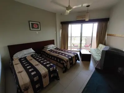 a hotel room with two beds and a couch at Jana View Condotel MN in Kamunting
