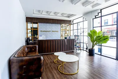 a living room with a leather couch and two tables at Earnest Hotel Georgetown in George Town