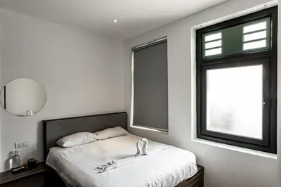 a bedroom with a bed and a window at Earnest Hotel Georgetown in George Town