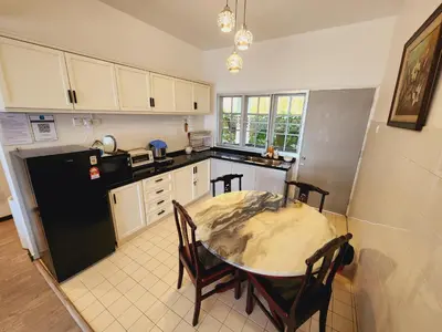 a kitchen with a table and a black refrigerator at Little England B5-2 Fraser Panorama in Bukit Fraser