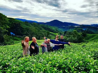 a group of people standing in a field of plants at A3A Oastel CoLiving in Tanah Rata