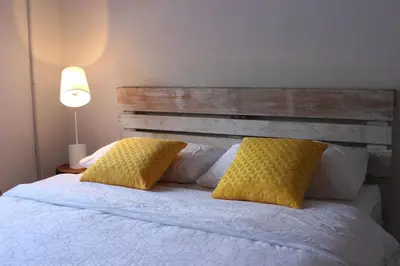 a bed with two yellow pillows and a wooden headboard at Tung's Factoria Cameron Highland in Cameron Highlands