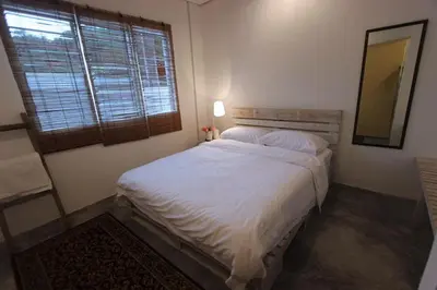 a bedroom with a bed with a mirror and a window at Tung's Factoria Cameron Highland in Cameron Highlands
