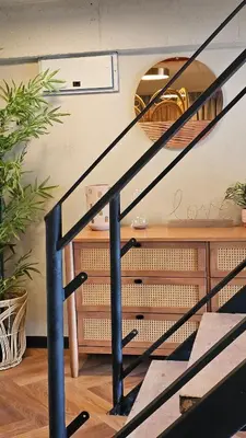 a black spiral staircase in a room with plants at A'moss Farmstay in Cameron Highlands