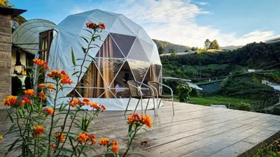 a dome tent sitting on top of a deck with flowers at A'moss Farmstay in Cameron Highlands