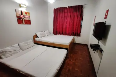 two beds in a room with a red window at Hotel Check Inn 2 Cameron Highlands in Brinchang