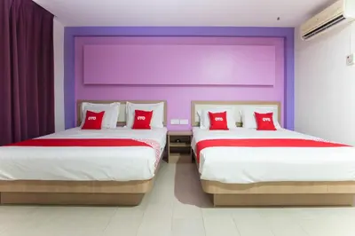 a bedroom with two beds with red pillows at Valley View Hotel in Lumut