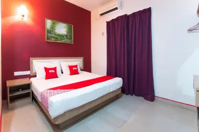 a bedroom with a large bed with red walls at Valley View Hotel in Lumut