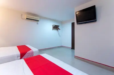 a room with two beds and a flat screen tv at Valley View Hotel in Lumut