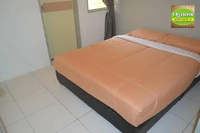 a bed with an orange comforter in a room at My Homestay N16 (14 pax) @ Golden Hills Night Market in Brinchang