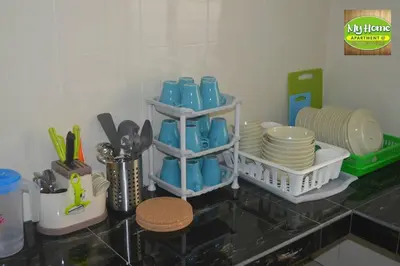 a kitchen counter with plates and utensils on a table at My Homestay N16 (14 pax) @ Golden Hills Night Market in Brinchang