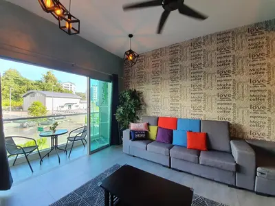 a living room with a couch with colorful pillows at Cameron Mossy Home @ Quintet in Tanah Rata