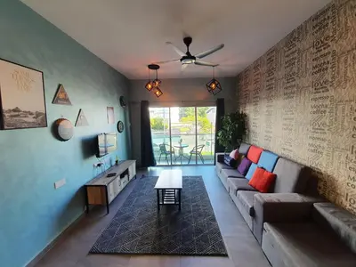 a living room with a couch and a table at Cameron Mossy Home @ Quintet in Tanah Rata