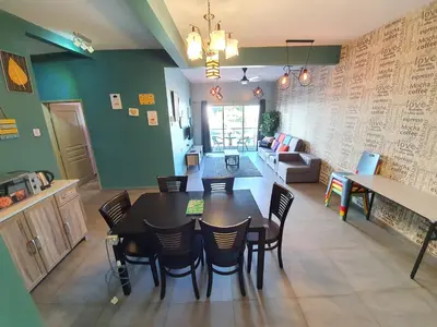 a dining room and living room with a table and chairs at Cameron Mossy Home @ Quintet in Tanah Rata