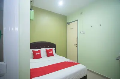 a bedroom with a bed with red pillows at Hotel O Rafik Ali Motel in Kepala Batas