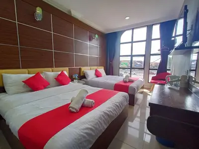 a bedroom with two beds with red and white pillows at Anggerik Garden Hotel - AG Hotel in Sitiawan