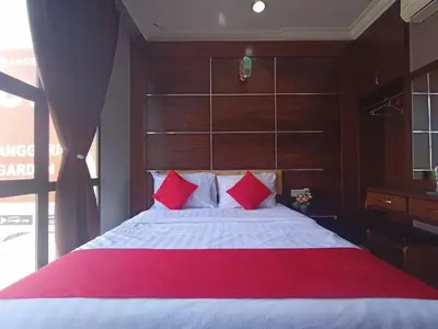 a bedroom with a large bed with red pillows at Anggerik Garden Hotel - AG Hotel in Sitiawan
