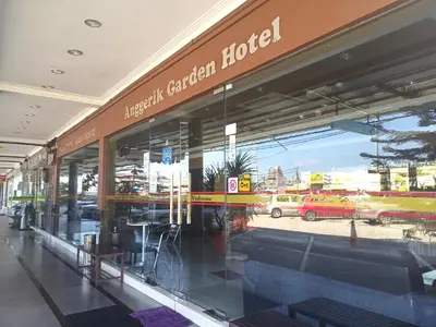 a store front of a car dealership with a reflection in the window at Anggerik Garden Hotel - AG Hotel in Sitiawan