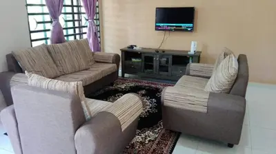 a living room with two couches and a tv at Nurul Homestay in Kepala Batas