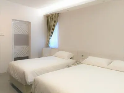 a bedroom with two beds and a window at Legacy Hotel Ipoh in Ipoh