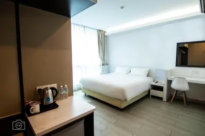 a bedroom with a bed and a desk and a television at Legacy Hotel Ipoh in Ipoh