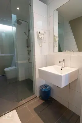 a bathroom with a sink and a glass shower at Legacy Hotel Ipoh in Ipoh