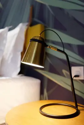 a lamp sitting on a table next to a bed at Sojourn Spa Hotel Ipoh in Ipoh