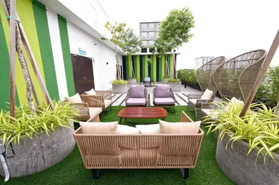 a patio with wicker chairs and tables and plants at Sojourn Spa Hotel Ipoh in Ipoh
