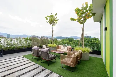a patio with chairs and a table on a roof at Sojourn Spa Hotel Ipoh in Ipoh