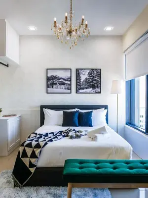 a bedroom with a large bed and a chandelier at Tropicana 218 Macalister Studio with Seaview in George Town