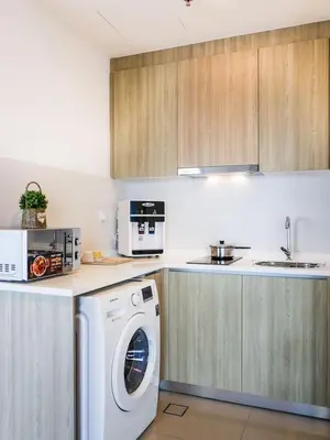 a kitchen with a washing machine and a microwave at Tropicana 218 Macalister Studio with Seaview in George Town