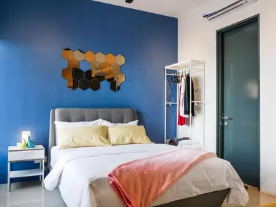 a bedroom with a bed with a blue wall at Tropicana 218 Macalister Studio with Seaview in George Town