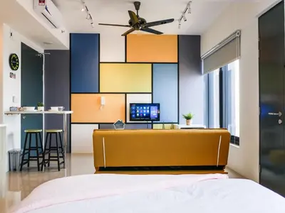 a bedroom with a bed and a desk with a computer at Tropicana 218 Macalister Studio with Seaview in George Town