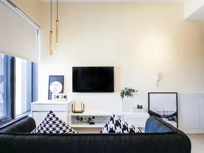 a living room with a black couch and a tv at Tropicana 218 Macalister Studio with Seaview in George Town
