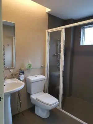 a bathroom with a toilet and a sink and a shower at Dear Dino House in Tanah Rata