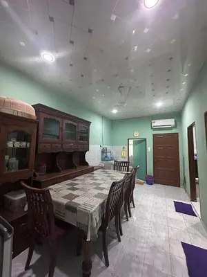 a large room with a table and chairs in it at AMIMAS HOMESTAY in Kampong Telok