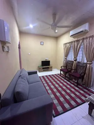 a living room with a blue couch and two chairs at AMIMAS HOMESTAY in Kampong Telok