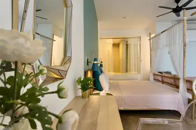 a bedroom with a bed and a mirror at Smell rose beach garden in Batu Ferringhi
