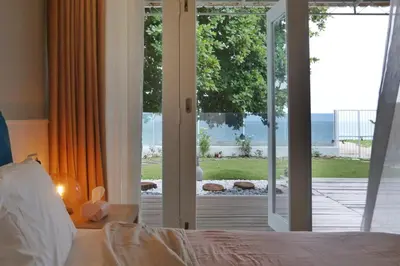 a bedroom with a bed and a sliding glass door at Smell rose beach garden in Batu Ferringhi