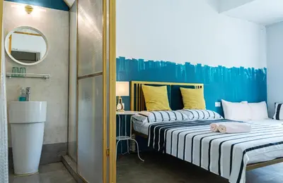 two beds in a small room with a mirror at Smell rose beach garden in Batu Ferringhi