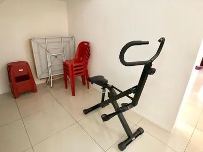 a room with a exercise bike and red chairs at Kampar Sakura 3 Landed in Kampar