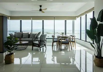 a living room with a couch and a table and chairs at Rumahku Gurney with 270 degree Sea View in George Town